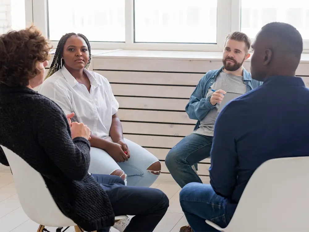 A diverse group of individuals participating in a support meeting at a drug and alcohol detox center in Nashville, promoting understanding and recovery.