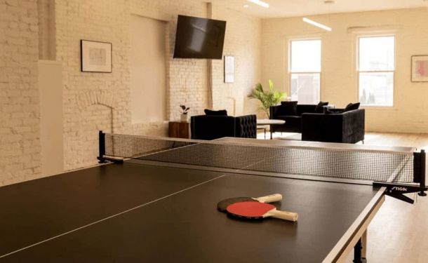 A recreational space with a ping pong table, paddles, and a cozy seating area at a drug and alcohol rehab center in Louisville, KY, promoting wellness and relaxation.