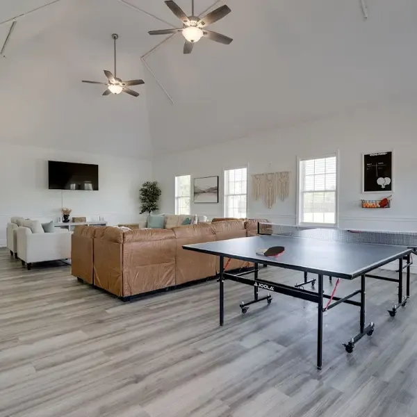 A spacious recreational room with a ping-pong table, couches, and natural light, illustrating the relaxing spaces at drug and alcohol treatment centers in Tennessee.